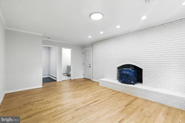 a view of an empty room with a fireplace and a window