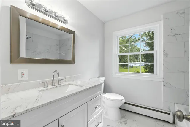 a bathroom with a toilet a sink and mirror