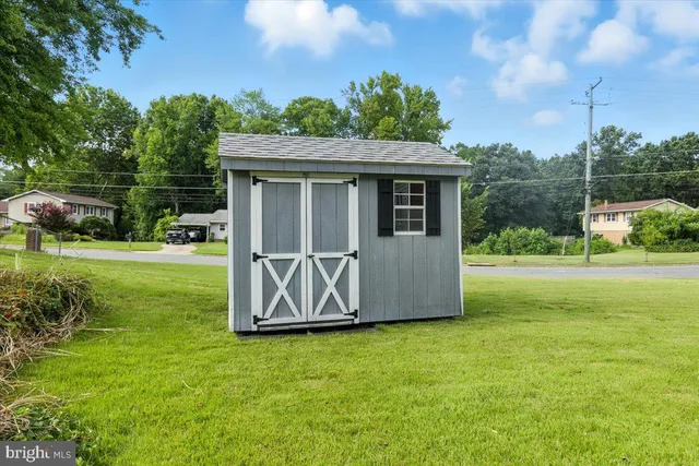 a view of a backyard with barn plants and large tree