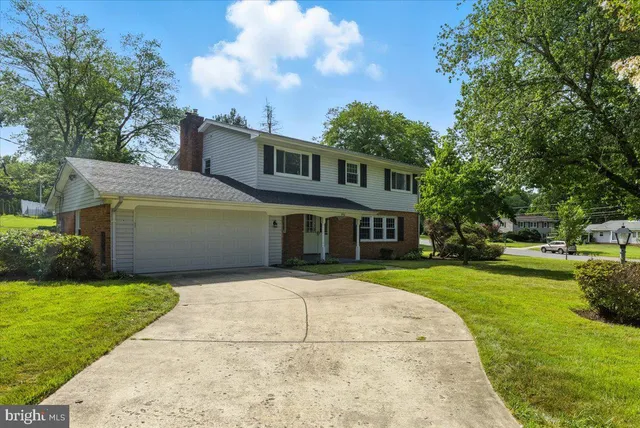 a front view of a house with a yard and trees