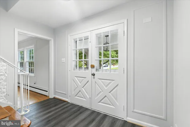 an entryway with wooden floor and windows
