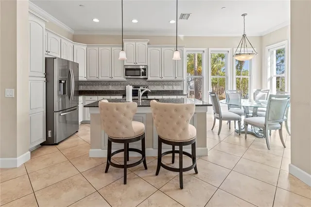 a dining room with furniture large windows and a chandelier