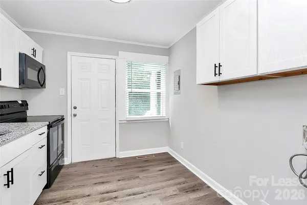 a view of a kitchen with wooden floor and electronic appliances