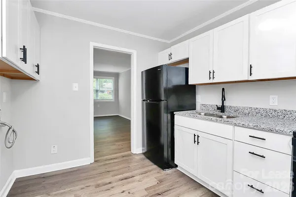 a kitchen with a sink a refrigerator and cabinets