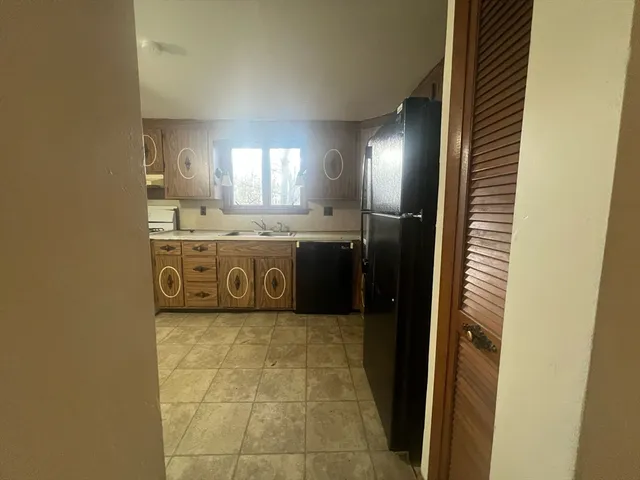 a kitchen with stainless steel appliances granite countertop a sink a stove and a refrigerator