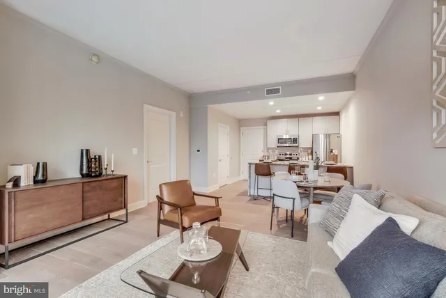 a living room with furniture and a dining table with kitchen view