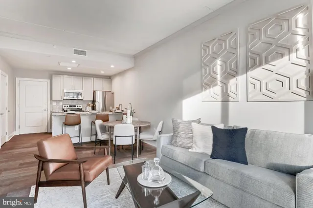 a living room with furniture and a view of kitchen