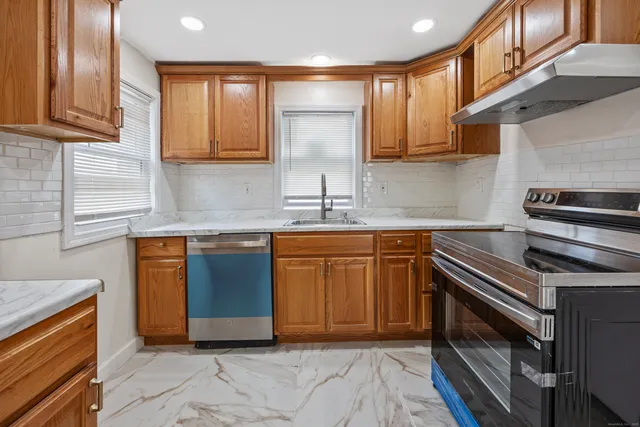 a kitchen with stainless steel appliances granite countertop a stove a sink and a microwave