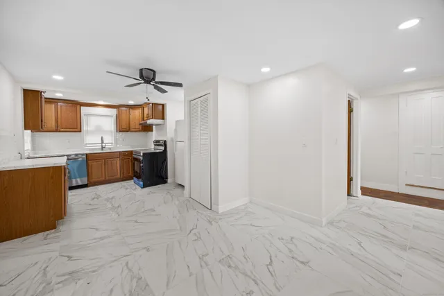 a large kitchen with stainless steel appliances granite countertop a refrigerator and a sink