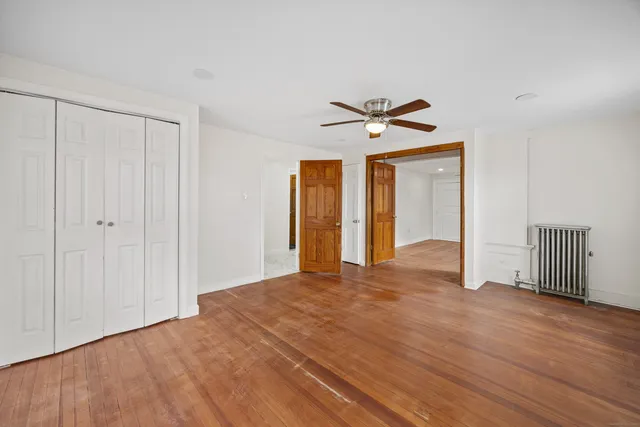 a view of a livingroom with wooden floor and a ceiling fan