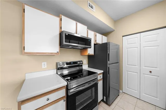 a kitchen with stainless steel appliances a refrigerator a stove a microwave and cabinets