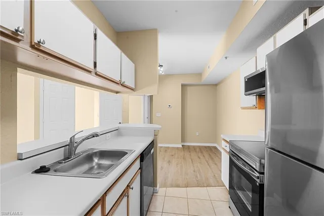 a kitchen that has a sink a stove and a refrigerator