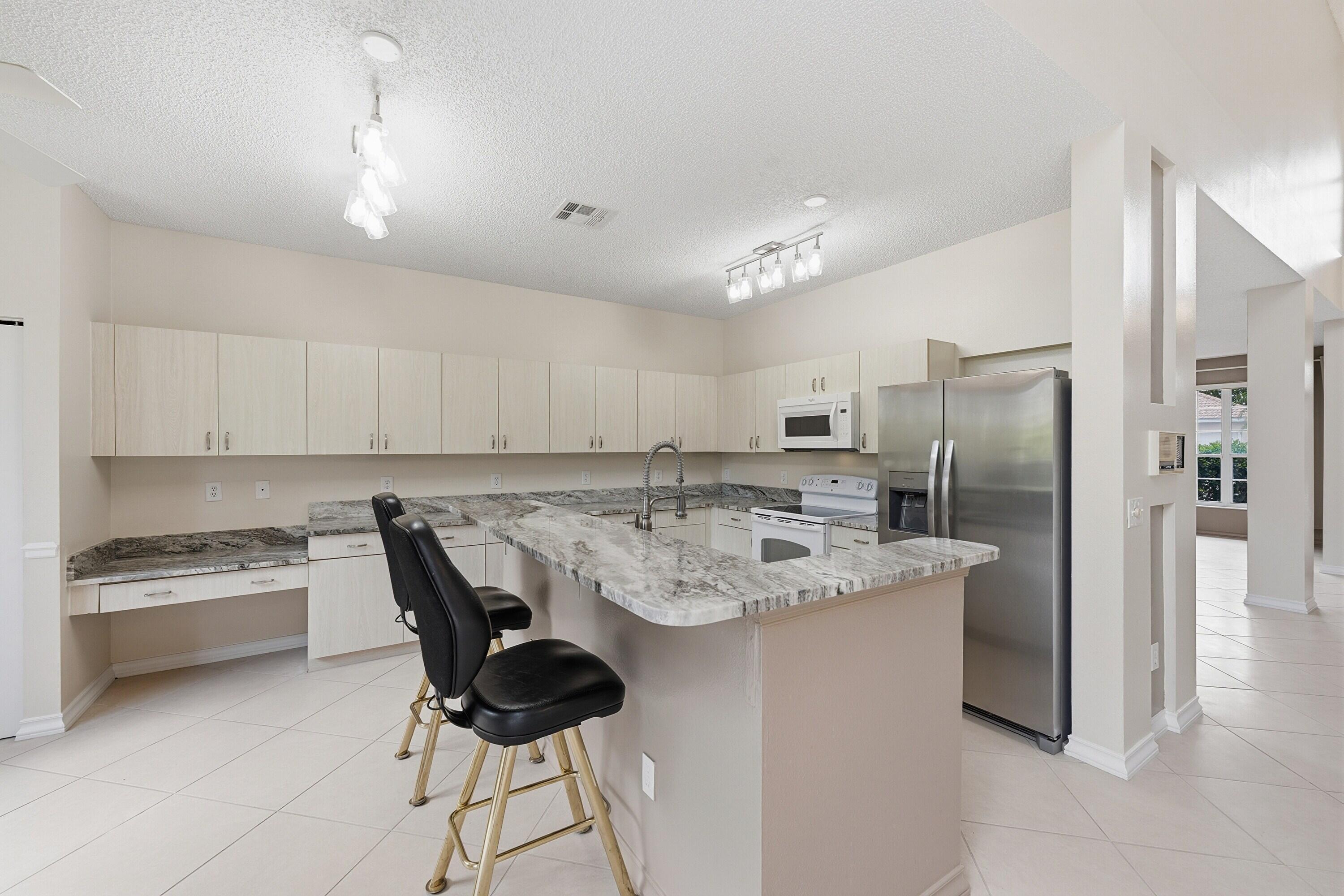 18474 Old Princeton Lane Boca Raton, FL 33498 - Photo 17 of 46 a kitchen with stainless steel appliances granite countertop a refrigerator and a stove top oven
