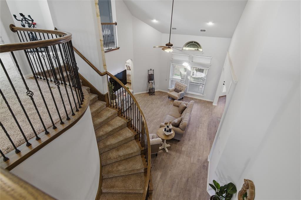 464 LeTara Ranch Drive Haslet, TX 76052 - Photo 31 of 37 Carpeted curved staircase with decorative wrought iron balusters and wood handrails