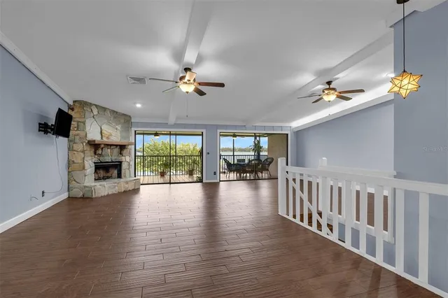 wooden floor fireplace and windows in an empty room