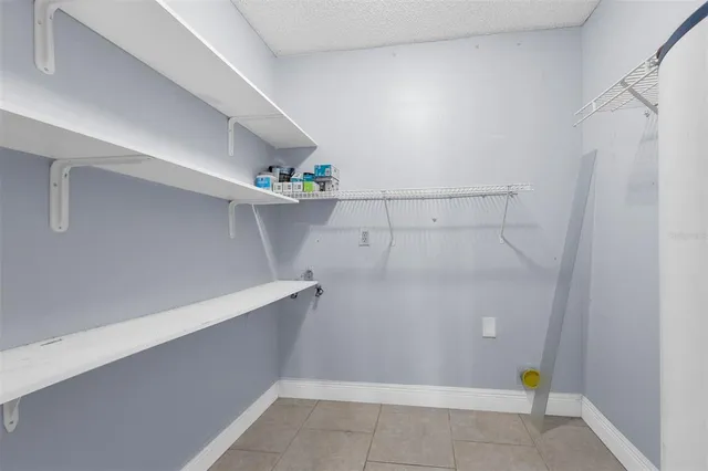 a view of an empty room with wooden floor fireplace and a window