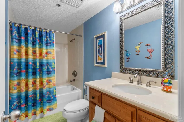 a bathroom with a sink a toilet and shower curtain
