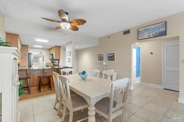 a view of a dining room with furniture and a chandelier fan