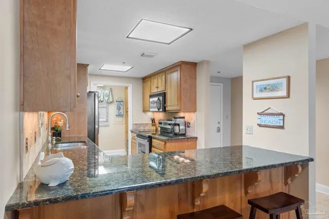 a kitchen with granite countertop a table chairs in it and wooden floors