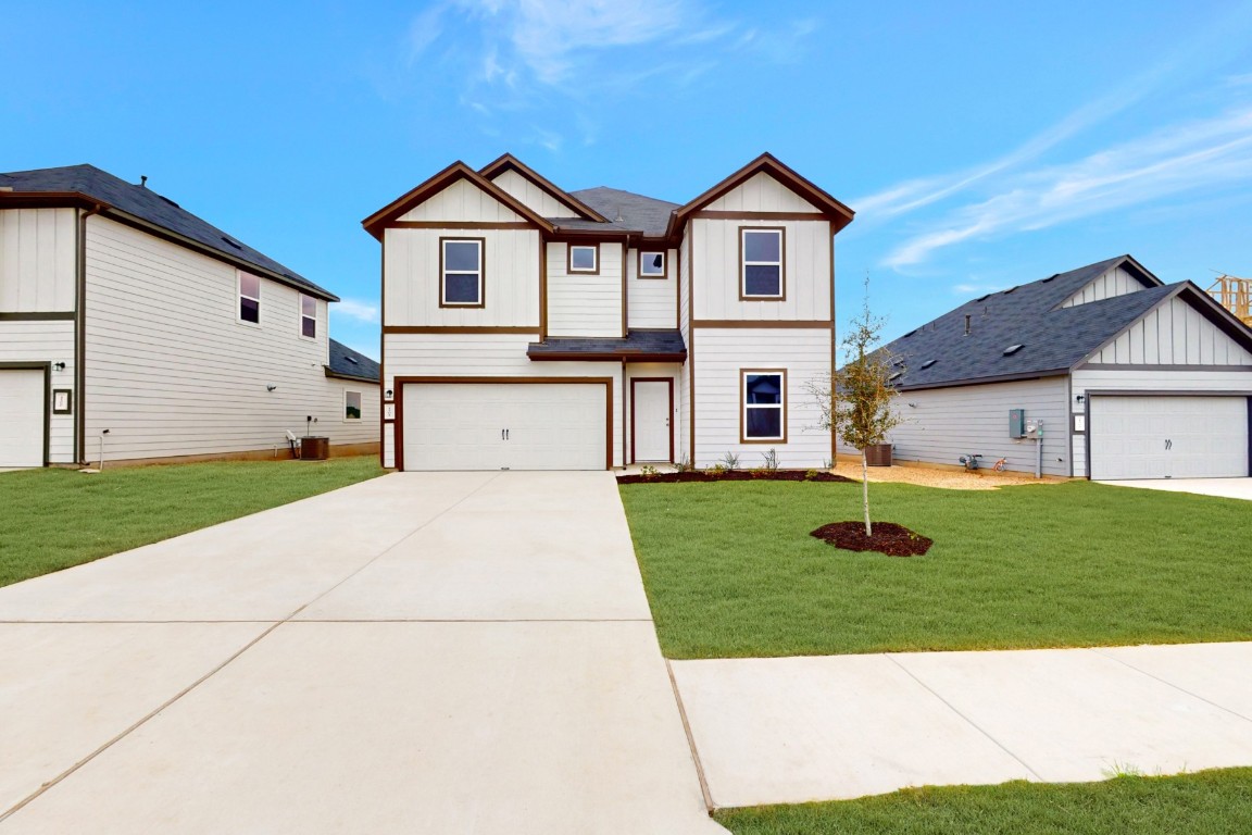 a front view of a house with a yard and garage