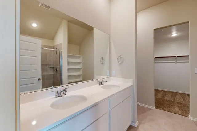 a bathroom with a double vanity sink and mirror