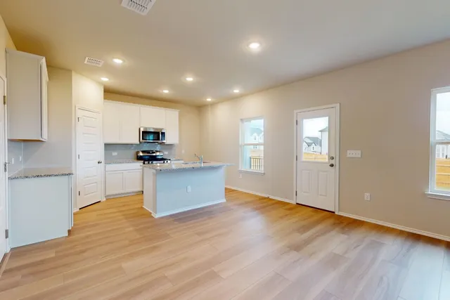 a view of kitchen with microwave and cabinets