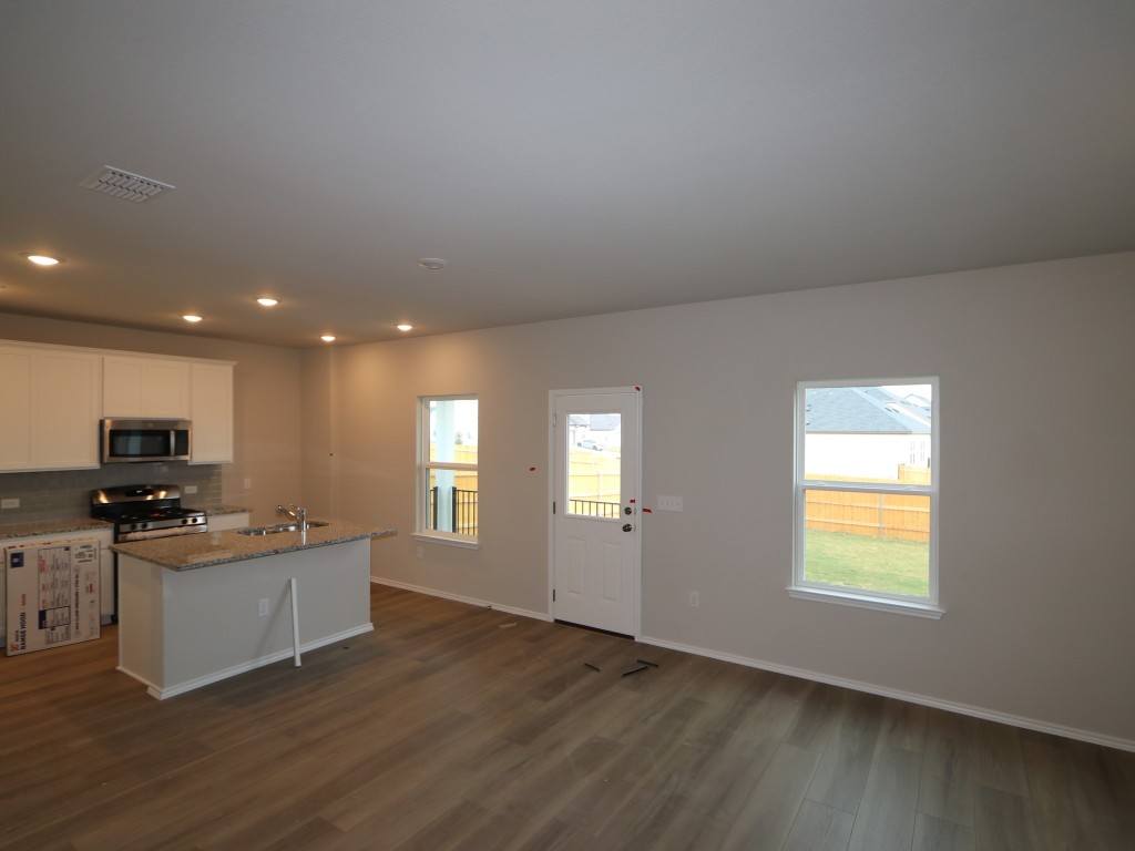 4504 Beacon Bay Drive Austin, TX 78747 - Photo 7 of 31 a kitchen with stainless steel appliances granite countertop a sink and cabinets