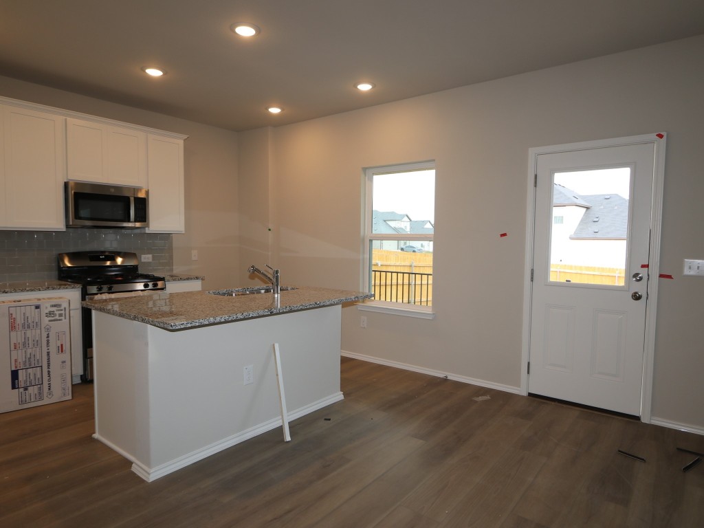 4504 Beacon Bay Drive Austin, TX 78747 - Photo 8 of 31 a kitchen with stainless steel appliances granite countertop a sink a stove a microwave a sink and a refrigerator