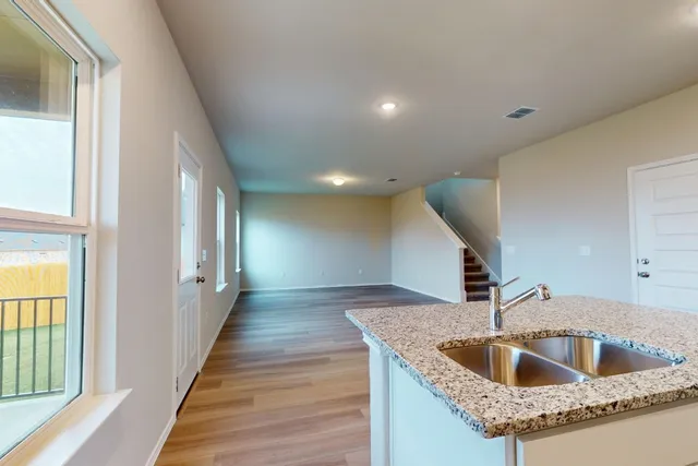 a kitchen with stainless steel appliances granite countertop a sink and a large window