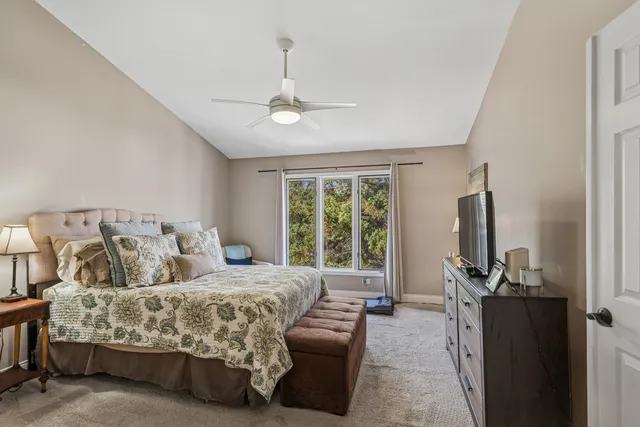 a bedroom with a bed flat screen tv and a large window