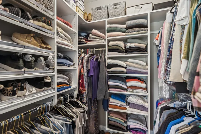 a view of walk in closet with clothes and shoes