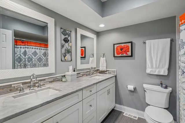 a bathroom with a toilet sink and mirror
