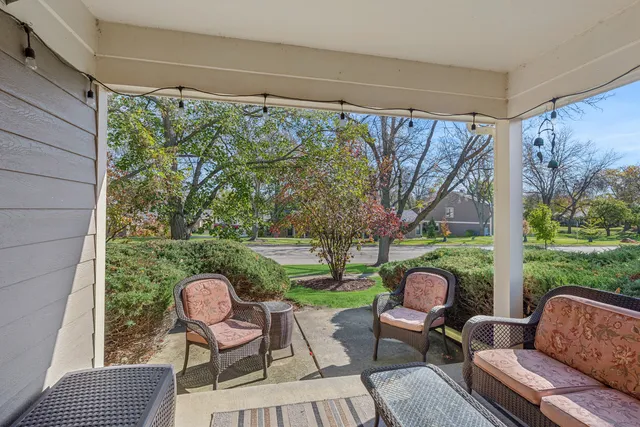 a view of a porch with furniture and a yard