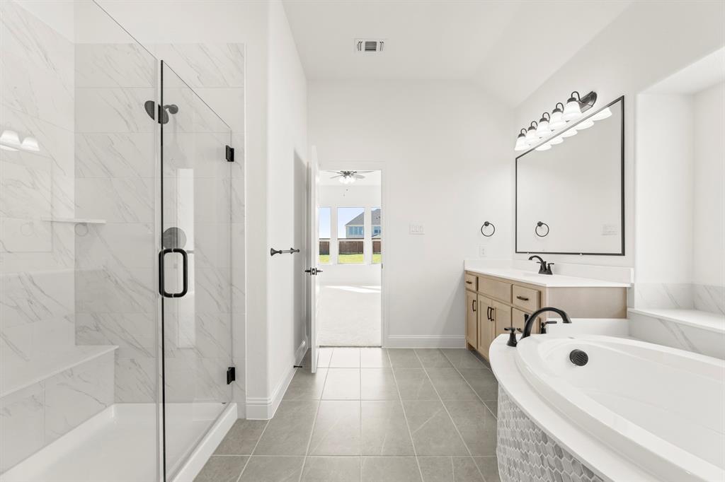 610 Tenor Drive Forney, TX 75126 - Photo 14 of 30 a bathroom with a tub sink a mirror and shower