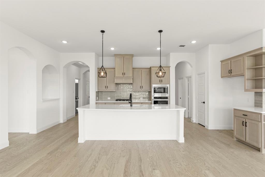 610 Tenor Drive Forney, TX 75126 - Photo 3 of 30 a large white kitchen with stainless steel appliances