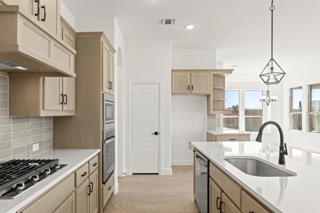 610 Tenor Drive Forney, TX 75126 - Photo 4 of 30 a kitchen with stainless steel appliances granite countertop a sink stove and refrigerator