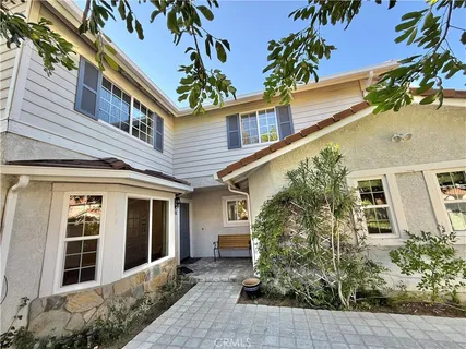 a view of a house with a small yard and wooden fence