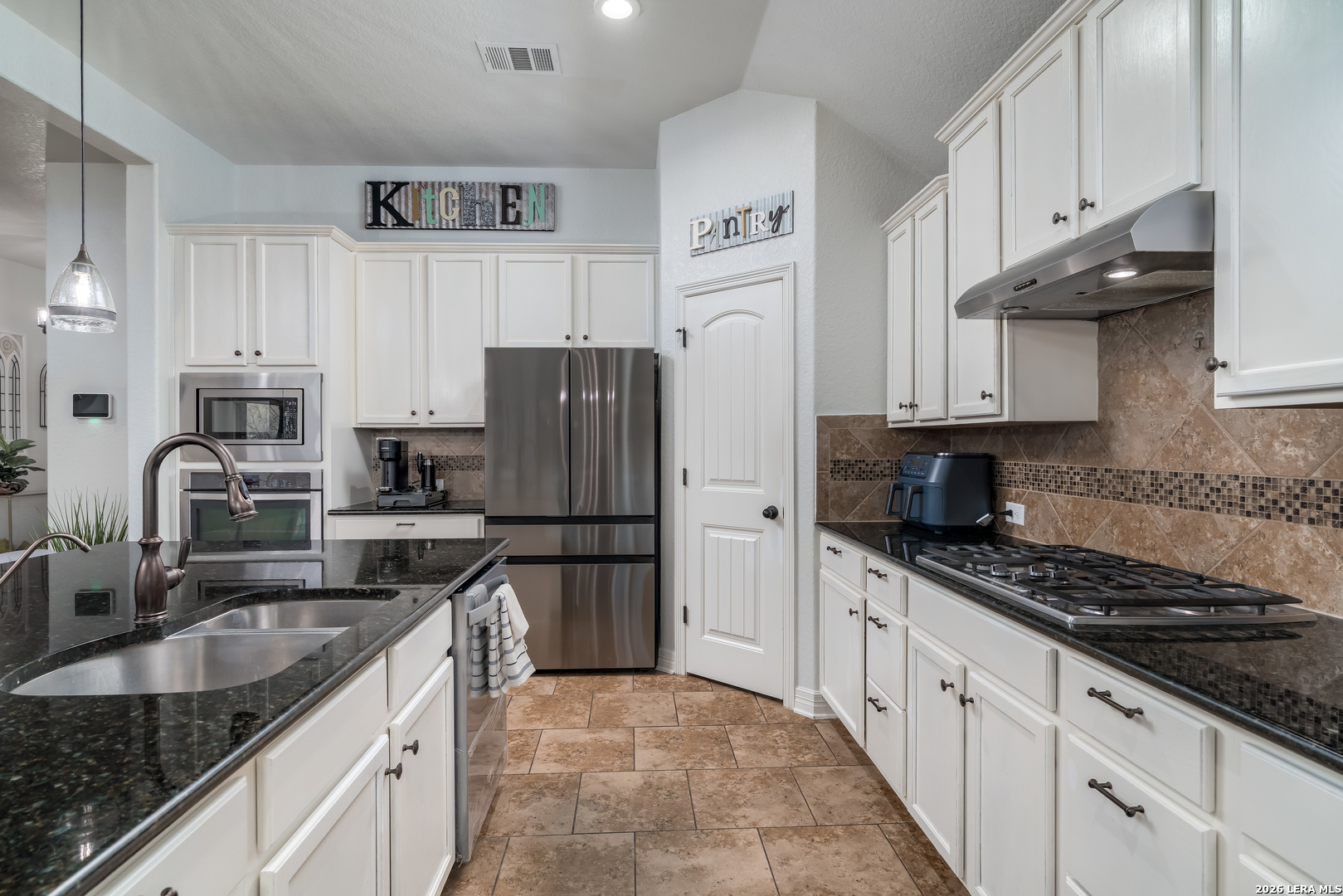 11331 Massive Mount Helotes, TX 78023 - Photo 11 of 43 a kitchen with stainless steel appliances granite countertop a sink stove and refrigerator