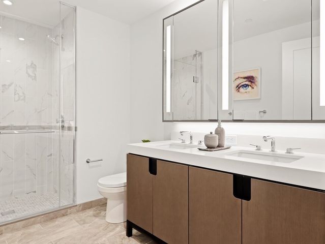 a bathroom with a granite countertop sink a toilet and a mirror