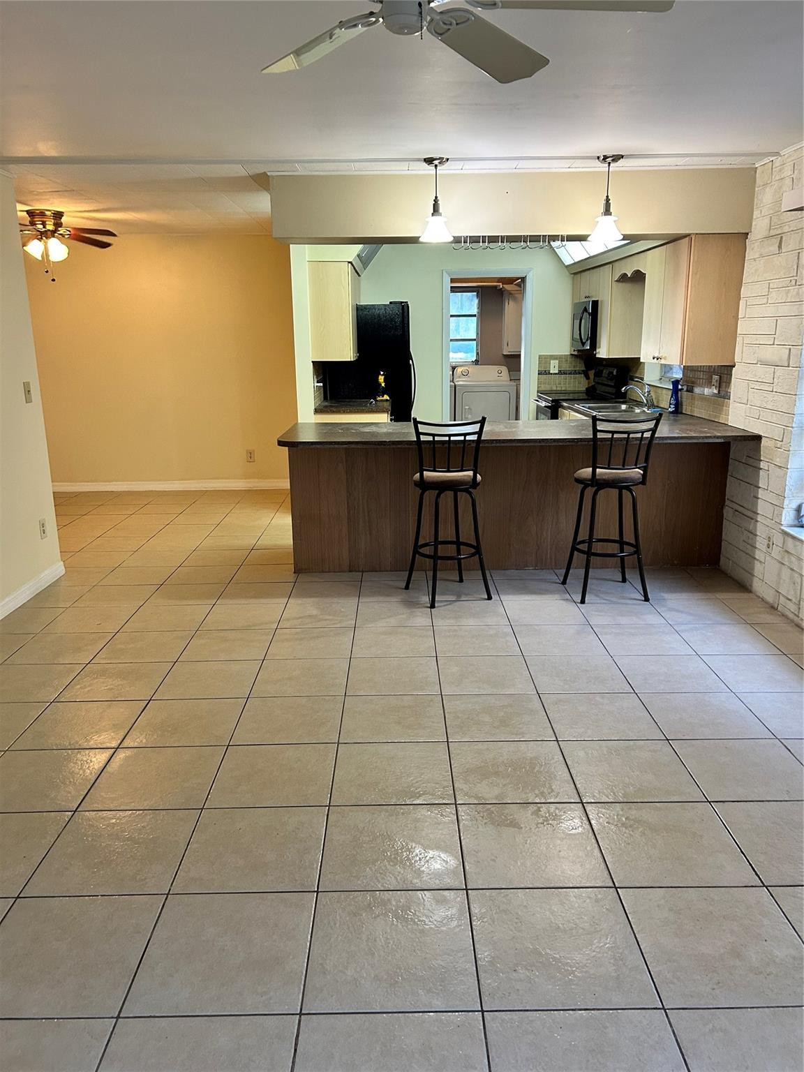 244 Southwest 3rd Place Dania Beach, FL 33004 - Photo 26 of 42 a view of a kitchen with kitchen island granite countertop a rug a stove a dining table and chair