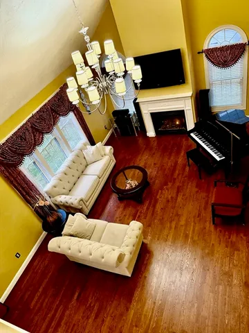 a view of a dining room with furniture a chandelier and wooden floor