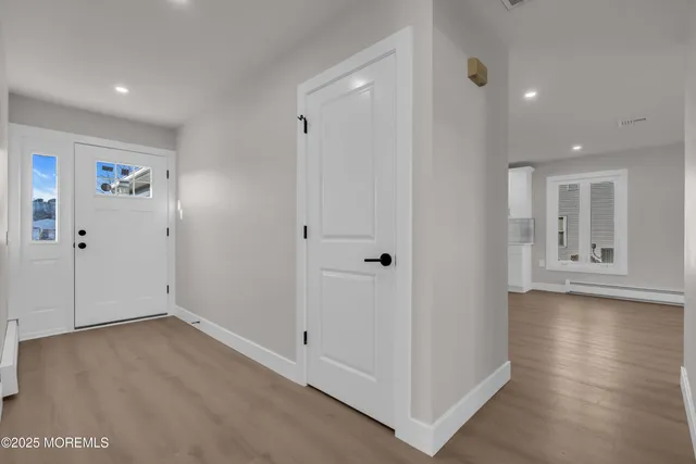 an empty room with wooden floor and window