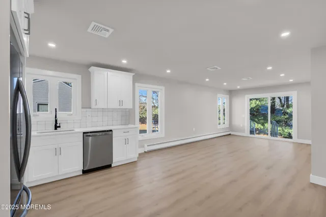 a kitchen with white cabinets stainless steel appliances and a sink