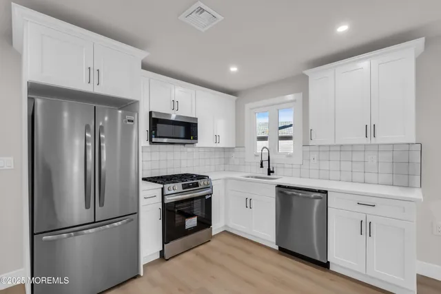 a kitchen with cabinets stainless steel appliances and a counter space