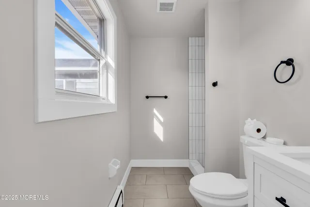 a bathroom with a toilet a sink and mirror