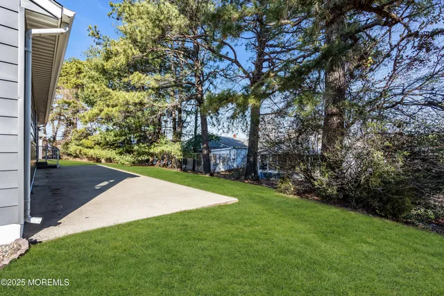 a view of backyard with wooden deck and a garden