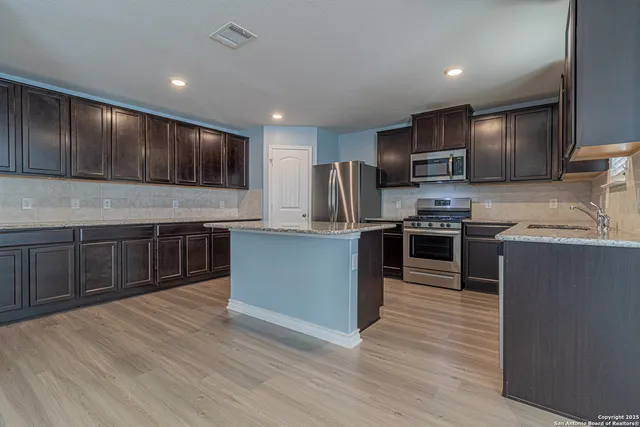 a kitchen with stainless steel appliances wooden cabinets and granite counter tops