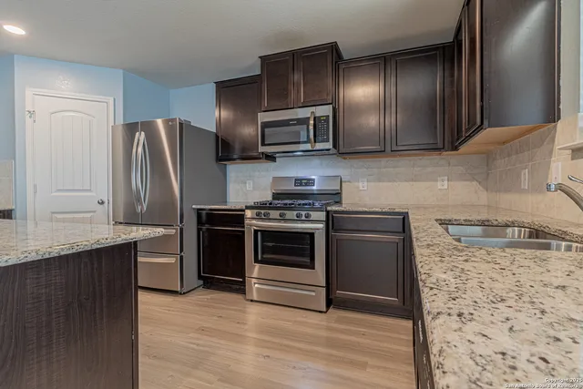 a kitchen with stainless steel appliances granite countertop a refrigerator stove and oven