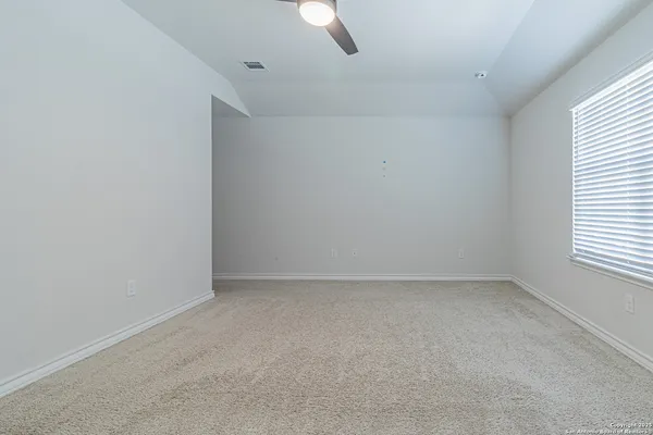 an empty room with a window and ceiling fan