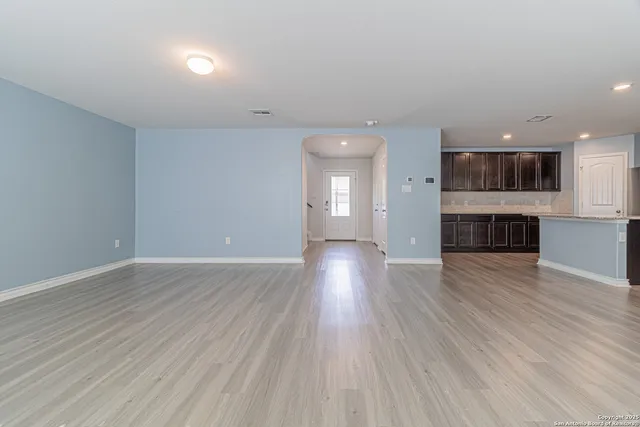 a view of a room with kitchen and wooden floor